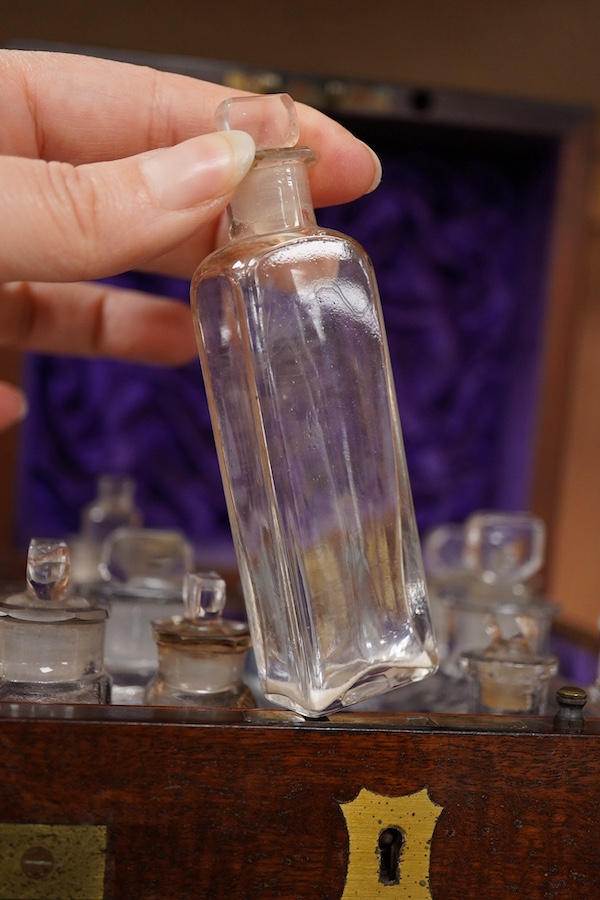 An early 19th century mahogany apothecary box, containing ten glass bottles, one with original paper label for the chemist Elam, 196 Oxford Street, London, with draw beneath containing a pair of scales, and weights, etc.